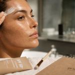 Bronzer au visage : application crème SPF 50 sur le front